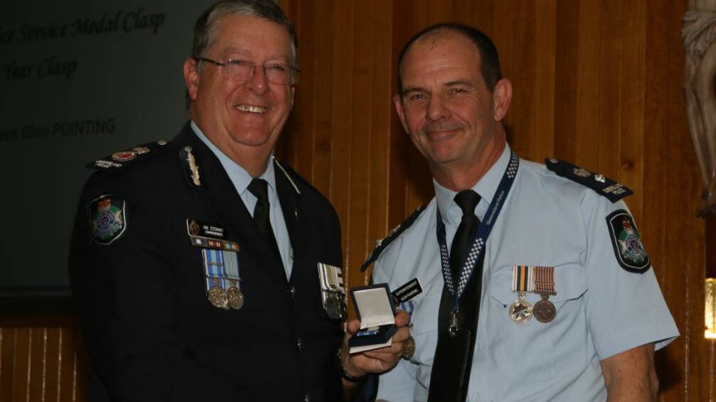Superintendent Glen Pointing receiving the 35 Year Clasp to the Queensland Police Service Medal from Commissioner Ian Stewart.