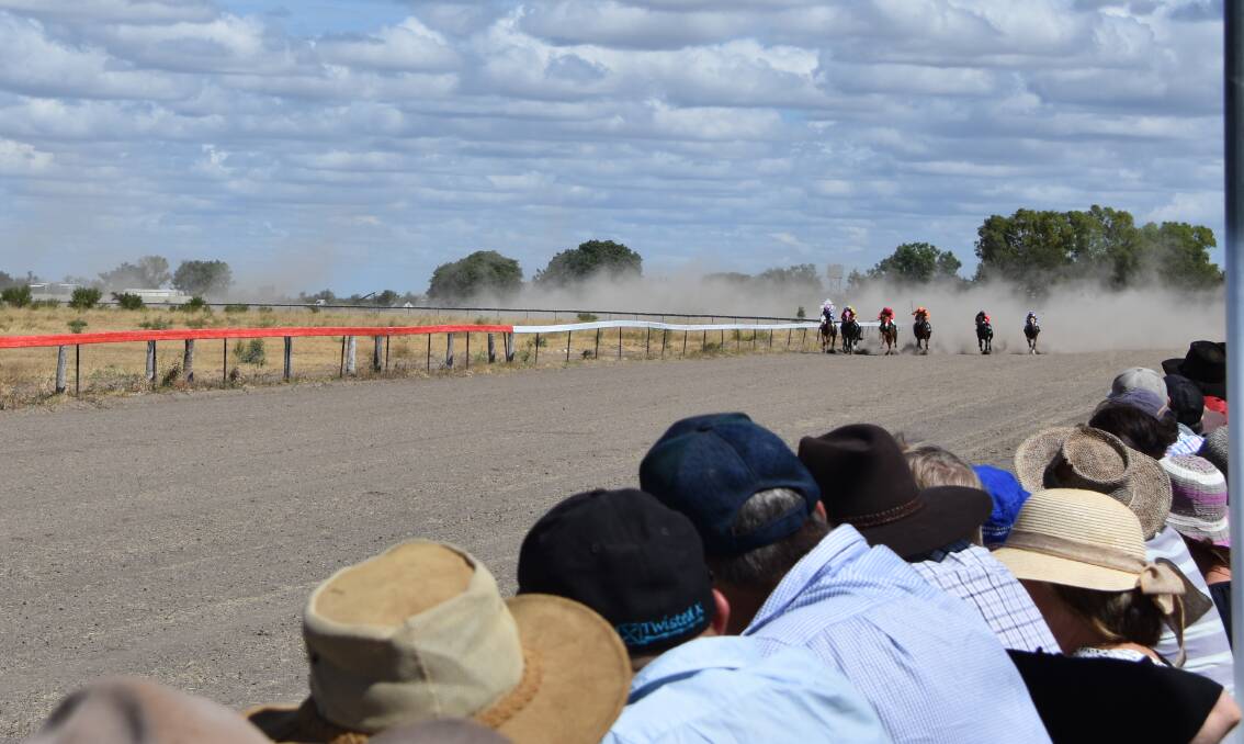 Punters gathered and hung over the fence as the horse and jockeys galloped to the finish line on Saturday at the Gregory Jockey Club race meet. Photo: Melissa North