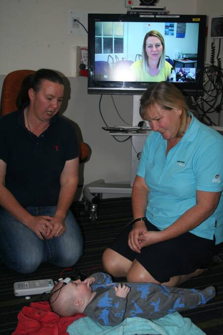 TELEAUDIOLOGY:Mum Julie Dorries, Senior Audiologist TeleAudiology, Children’s Health, Jane Fitzgibbons on the video monitor, and NWHHS midwife Mary Lucas on the follow up teleconference regarding baby Brodie.