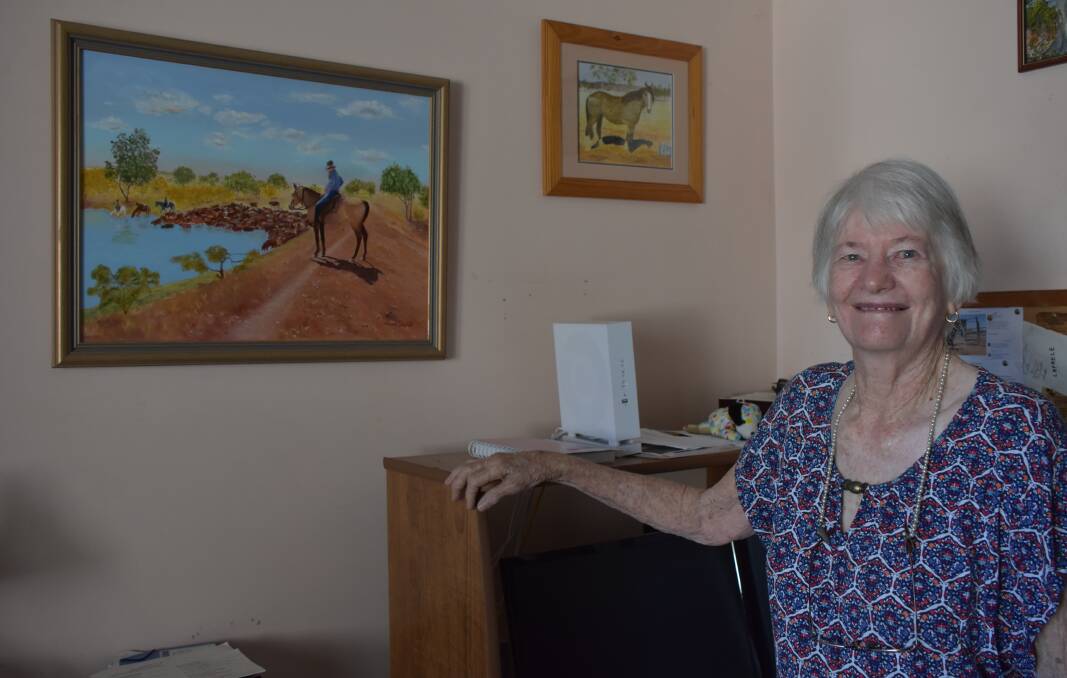 Margaret Campbell with one of her favourite paintings, featuring her son Ian mustering cattle on their property. Photo: Samantha Walton.