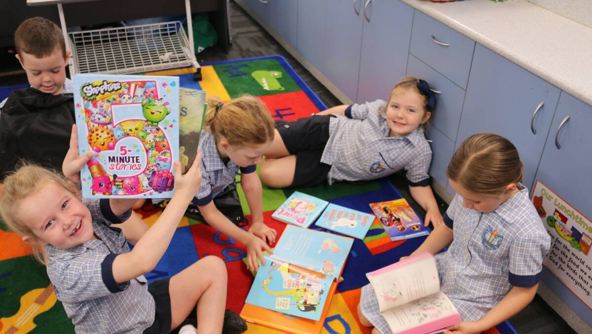 Cloncurry St Joseph's School students show off their new books.