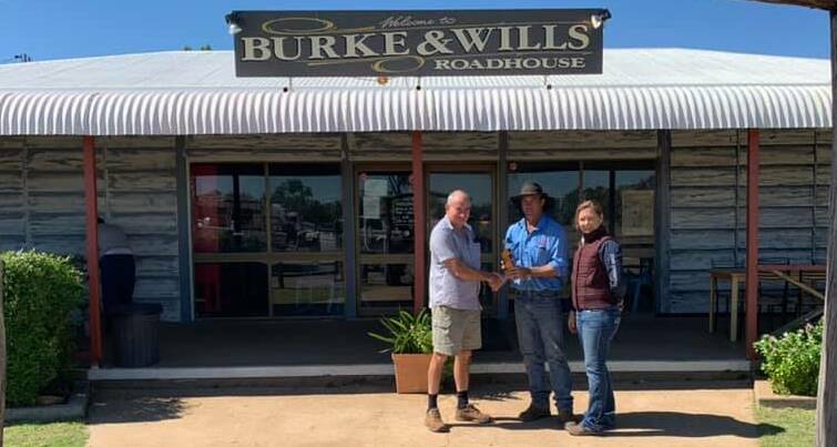 Owen Rankine hands over the keys to the Burke and Wills Roadhouse to Ben and Cheri Stanger. Photo supplied.