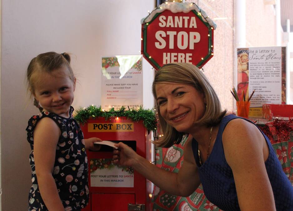 MAIL: Mayor Joyce McCulloch helps Vivienne Moore, 3, to post her letter to Santa at Santa’s Mount Isa City Library postbox. Photo: Samantha Walton.