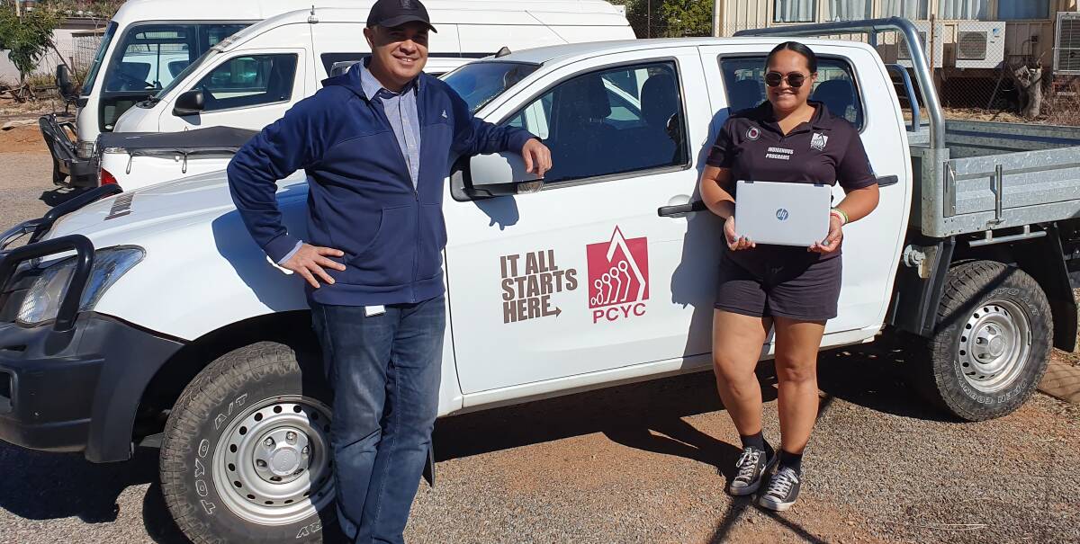Local legend Tom Atu donating his laptop to youth support officer Jazmyn Slater.