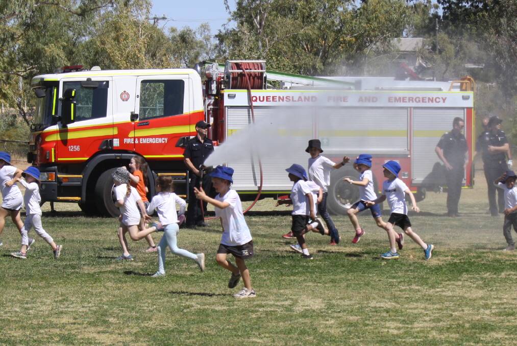 SPLASH AND DASH: Mount Isa firefighters spray kids with water on part of the dash. 