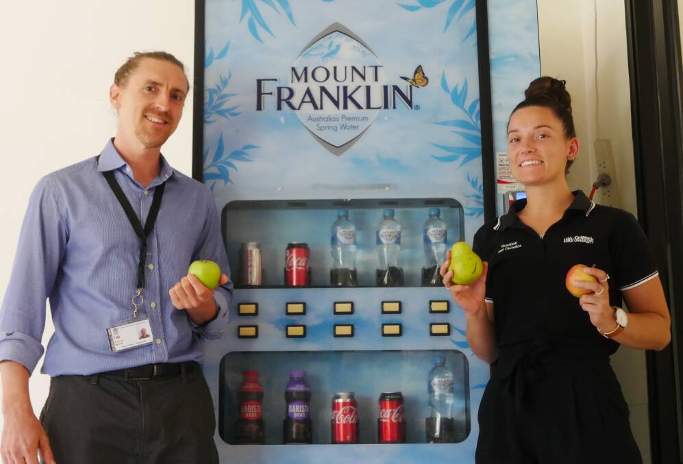 EAT RIGHT: Dietitian Tim Matthews and JCU placement nutrition student Kirby Sorenson showing off green choices in front of a vending machine. Photo: Aidan Green