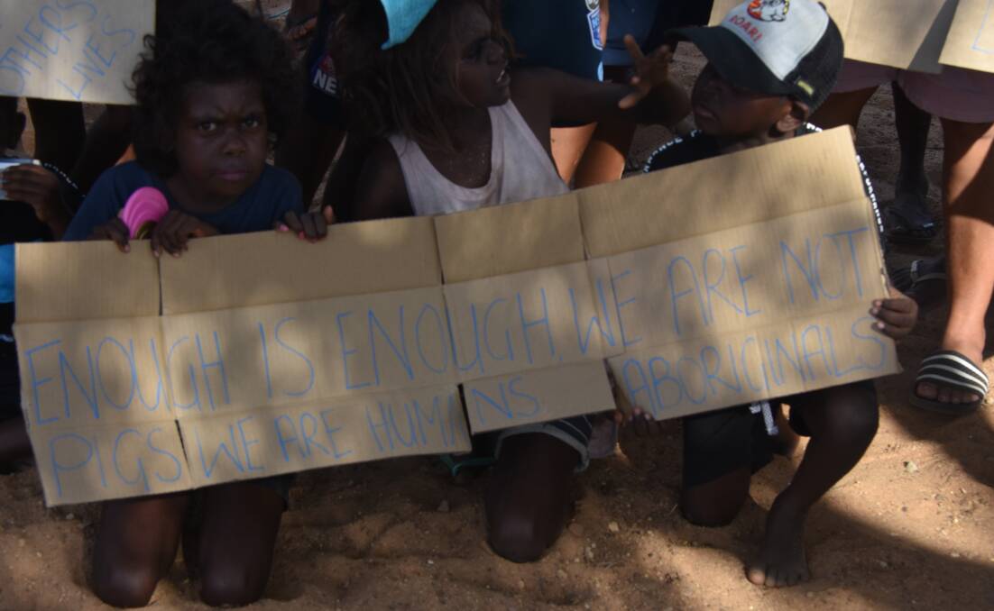 ENOUGH: Just one of the many signs at Monday's protest in Doomadgee. Photo: Aidan Green