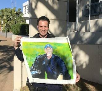 Sergeant Mick Silman with the canvas portrait of him at PD Flynn.