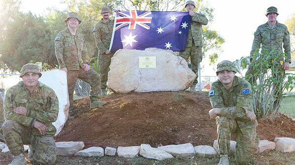 Australian Army soldiers from C Squadron, the 2nd Cavalry Regiment, stand by the refurbished Anzac memorial at Urandangi. Photo: ADF