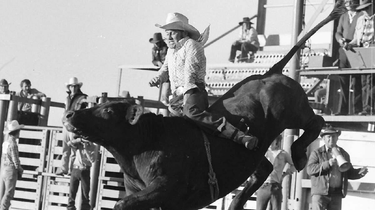 PAST MASTER: The bull keeps an eye on his rider at the Mount Isa Rodeo sometime in the 1970s.