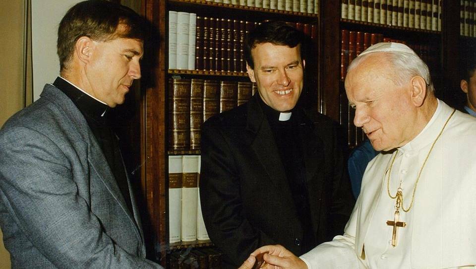 Father Mick Lowcock (left) explained to Pope John Paul II where Mount Isa was when they met in the Vatican in 1995