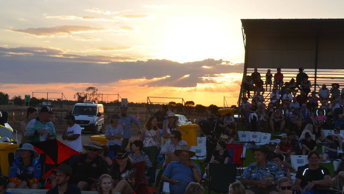 The sun goes down on Winton Showgrounds as the crowd enjoys the Dunny Derby during the Outback Festival last week.