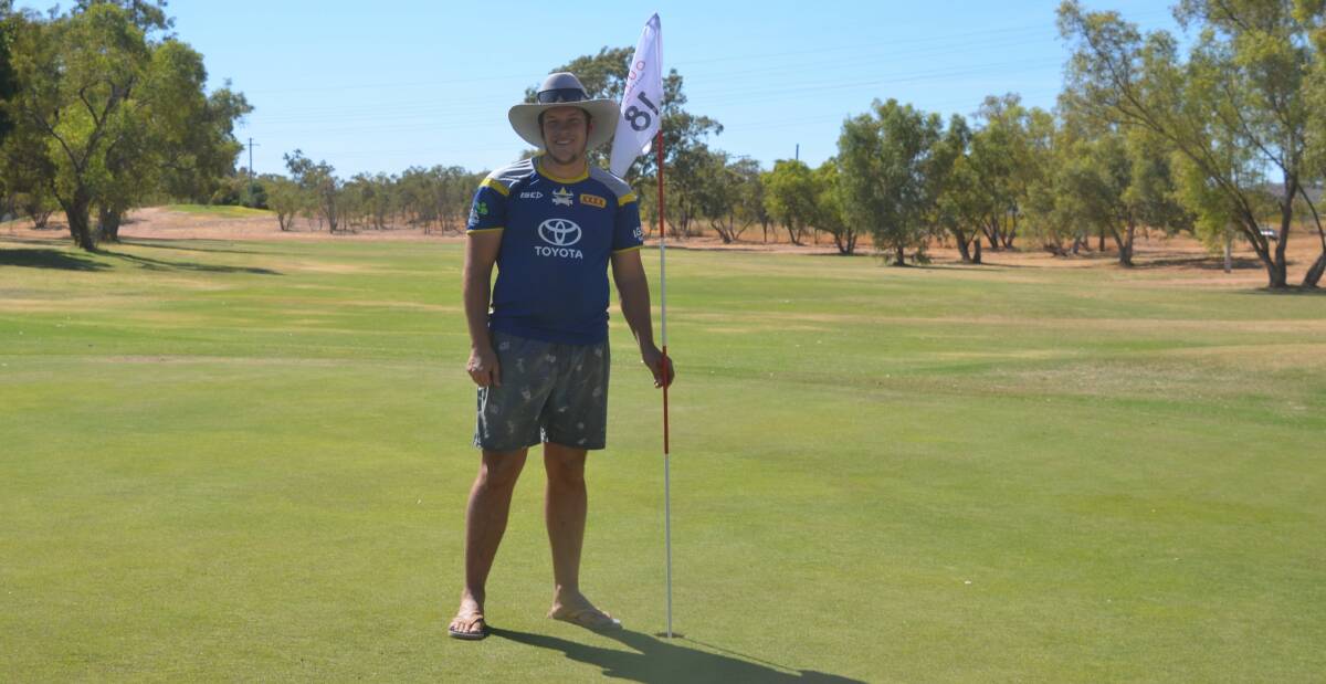 PUTT POSITION: Bailey McDonald puts the competition flag in place on the 18th green ahead of Mount Isa's Outback Masters. Photo: Derek Barry
