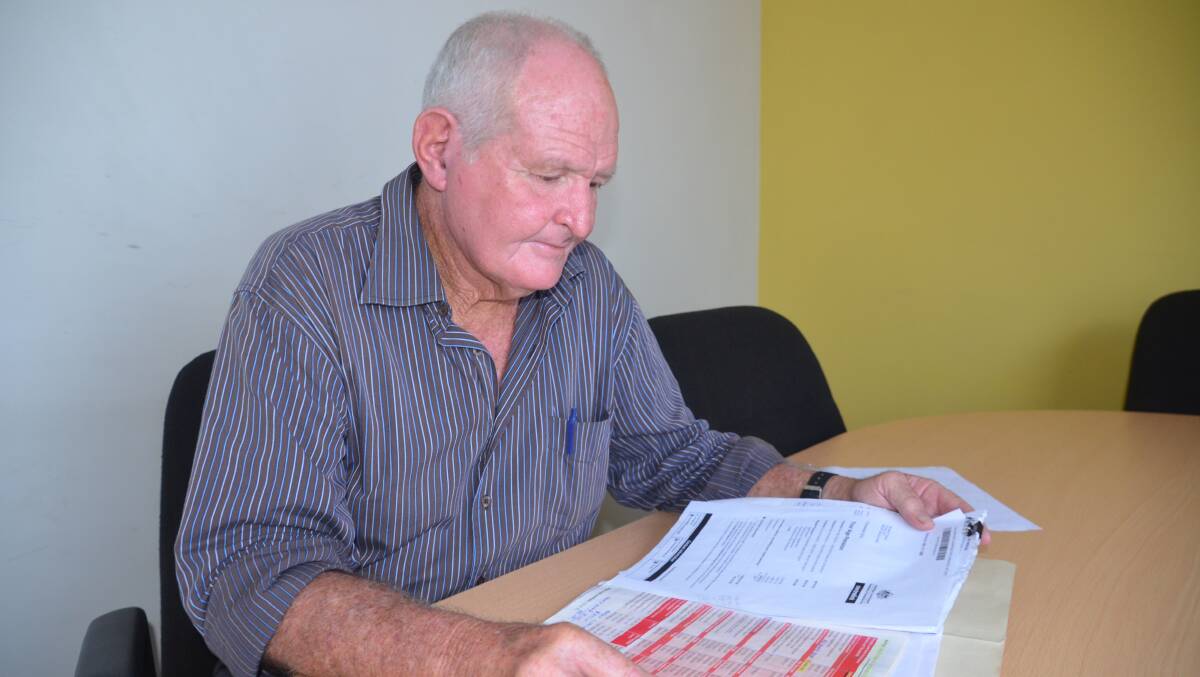 HEAVY BLOW: Kevin Kenna looks through the government papers which show his pension will be halved in 2017.