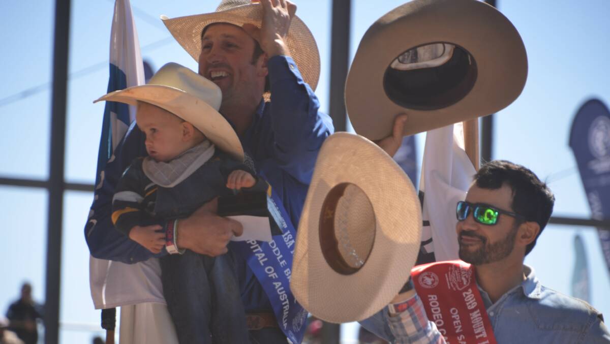 HATS OFF: Mount Isa Mines Rodeo open saddle bronc winner Cody Angland takes his young son on a victory lap of the Buchanan Park arena. Photo: Derek Barry