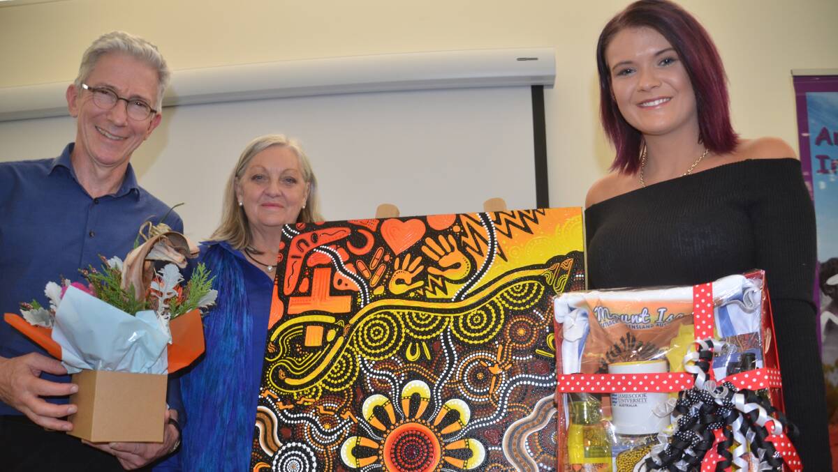 LAUNCH: JCU Professors Richard Murray and Sabina Knight help Chern'ee Sutton (right) unveil her painting Caring for Community. Photo: Derek Barry