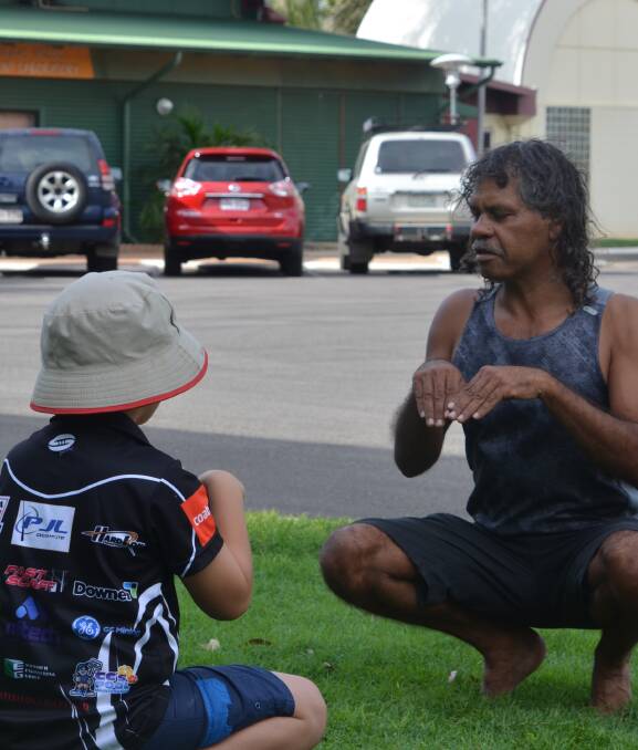 INDIGENOUS CULTURE: Shawn Major teaches Mount Isa kids how to imitate a kangaroo in traditional dances. Photo: Derek Barry