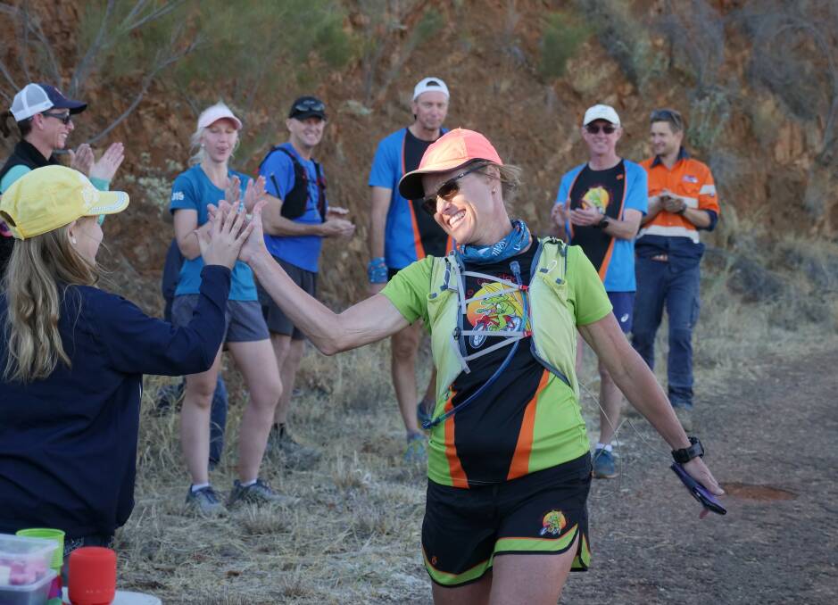 100 LAPS: Alison Whitehead high fives supporters as she finishes her challenge on Saturday evening. Photo: Kelly Butterworth/ABC North West Queensland.