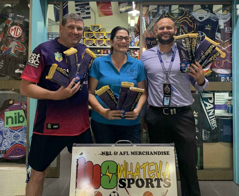 Rob Gleeson from Whateva Sports, Loretta Gladstone from Zonta and A/Sgt Dean Hanrahan with the purple socks they will give out at City v Country on Friday.