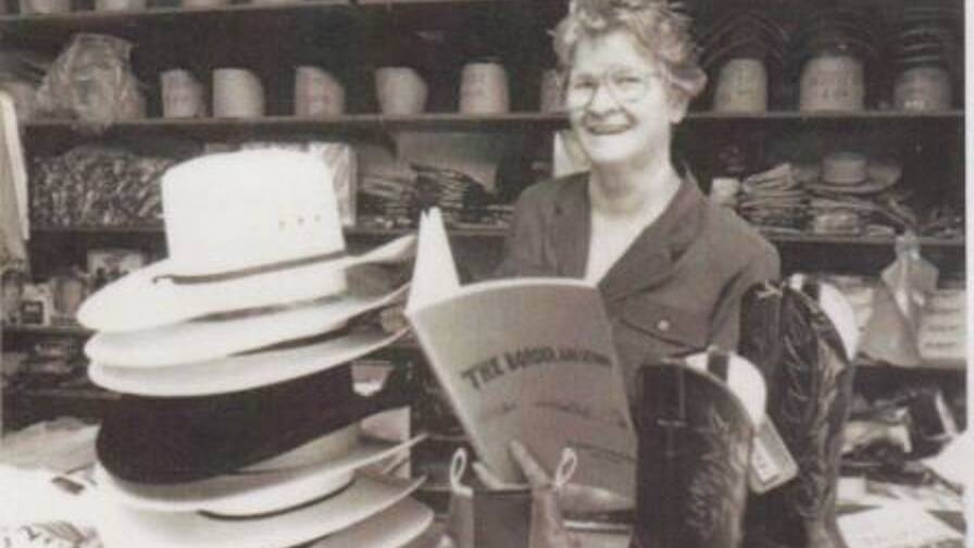 Ada Miller reading her book The Border and Beyond Camooweal 1884-1984 behind the counter of Freckleton's Store, Camooweal ca 1984.