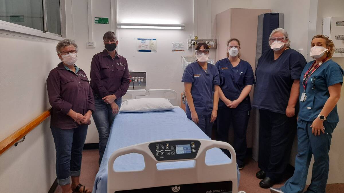Liz Debney and Rowena Murphy display the new palliative care bed with Cloncurry Hospital staff: Sherry Walton Nurse Unit Manager, Morgan Bennett Discharge Planner, Karen McIntosh Clinical Facilitator and Leonie Fromberg Medical Superintendent.