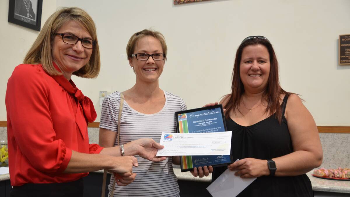ALL SMILES: Mount Isa Mayor Joyce McCulloch presents North West Gymnastics's Kylie Brooke and Veronica Marsh a community grants cheque. Photo: Derek Barry