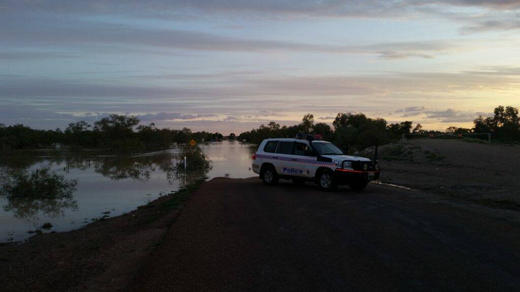 Senior Constable Kurt Dunlop inspecting the floodwaters at Eyre Creek – the bridge is still submerged 
