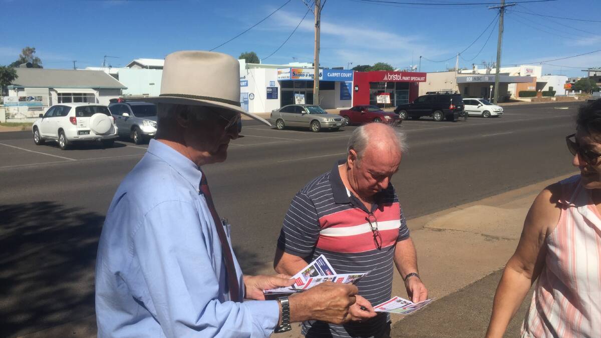 Bob Katter hands out how to vote cards at the Mount Isa pre-poll centre on Thursday.
