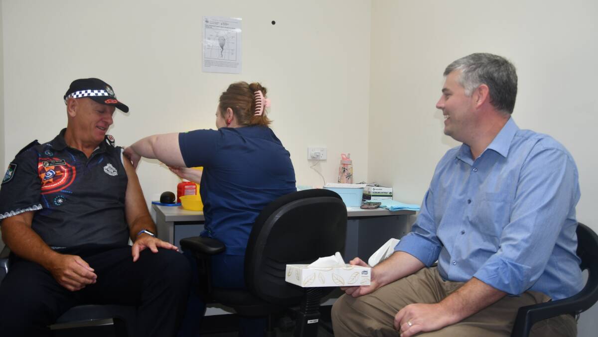 Minister Ryan watches on as Asst Commissioner Taylor gets his booster shot at the Mount Isa Vaccination Centre.