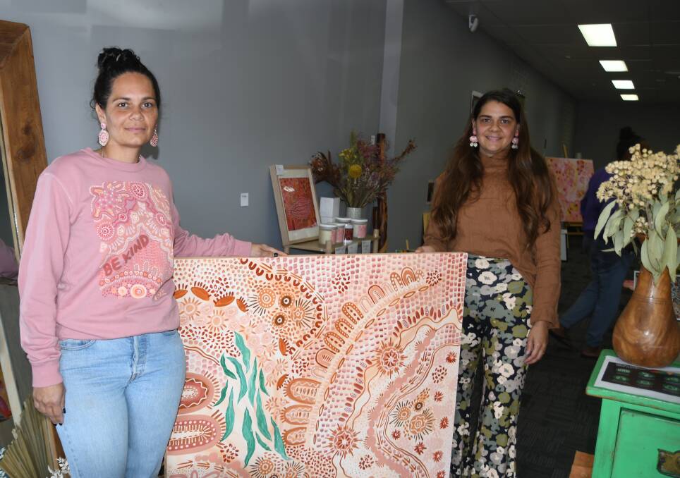 Jaunita Doyle and Cheryl Perez with one of the art works in the pop up shop.