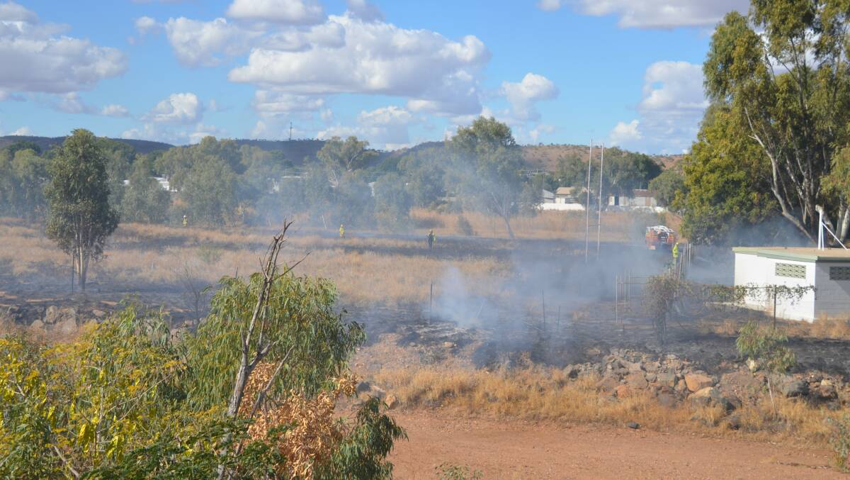 Firies are at the scene of a grass fire at the back of the Mount Isa rugby grounds.