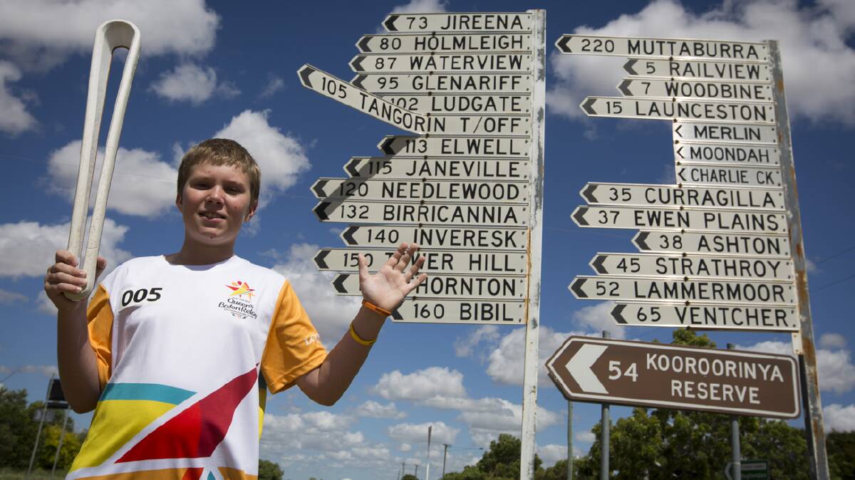 PROUD HOLDER: Cameron Dart holds the Queen's Baton aloft in the Commonwealth Games relay at Prairie on Monday. Photo: supplied.