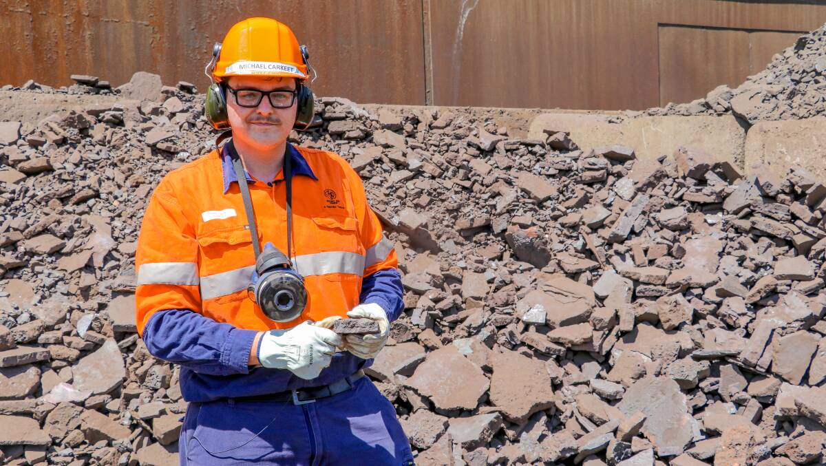 Copper Smelter Plant Metallurgist Michael Carkeet inspects cooled and hardened skim which is broken into small pieces so it can be re-processed through the Copper Smelter. Photo: supplied