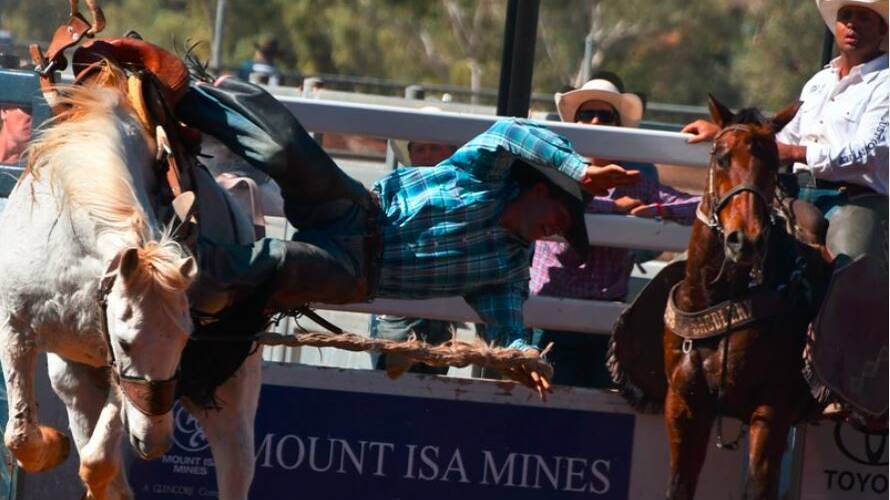 Heath Chalmers about to be grounded in the open saddle broncs final at the Mount Isa Rodeo. Photo: Derek Barry
