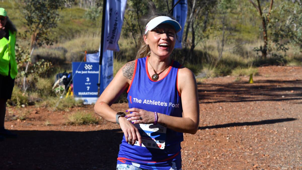 One of the national runners Jess Peil from Canberra manages a small as she runs her marathon in Mount Isa.