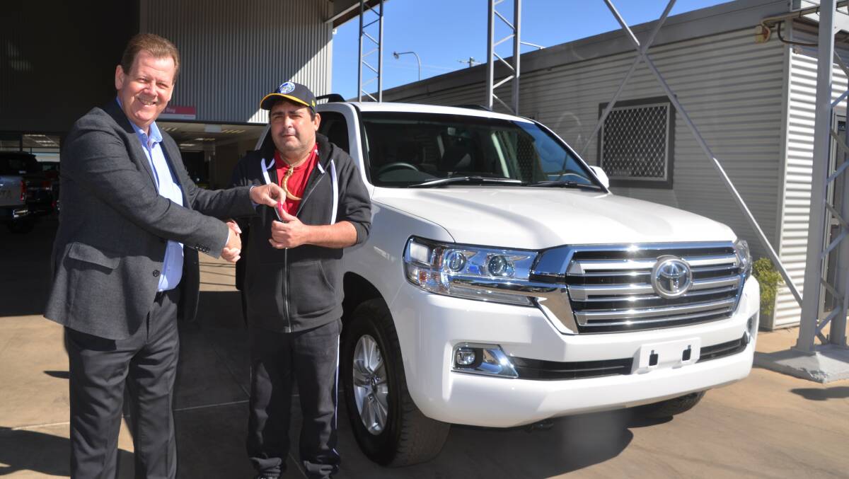 WINNER: Bell & Moir principal Lee Pullman presents Kerwyn Wondunna with the Land Cruiser first prize in the Isa Rodeo Art union draw.