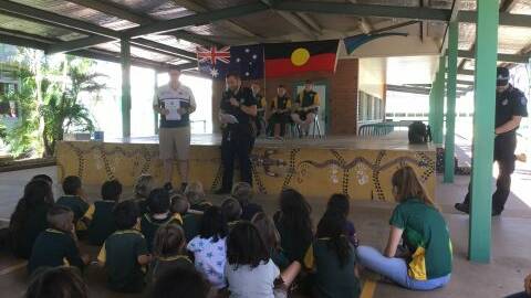 Principal David Hardy and Officer Lincoln address the students at Healy State School.