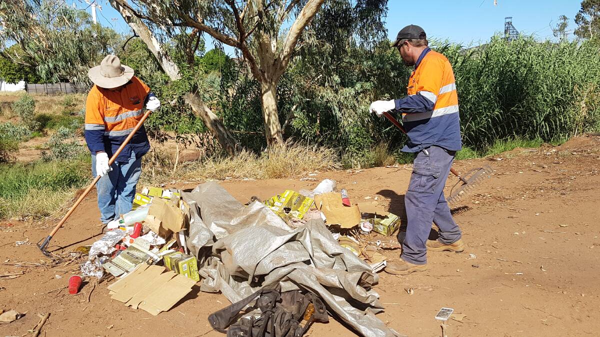 CLEAN UP: Council staff collect rubbish from the riverbed on Wednesday.