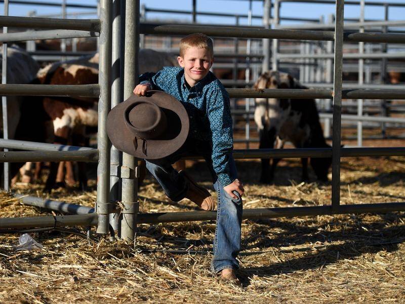 Riley Schmidt, 10, has claimed the poddy calf ride final at the Mount Isa Rodeo.