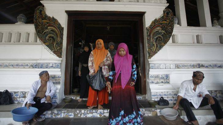 Men hold containers for donations from visiting pilgrims outside the  tomb area. Photo: Irwin Fedriansyah