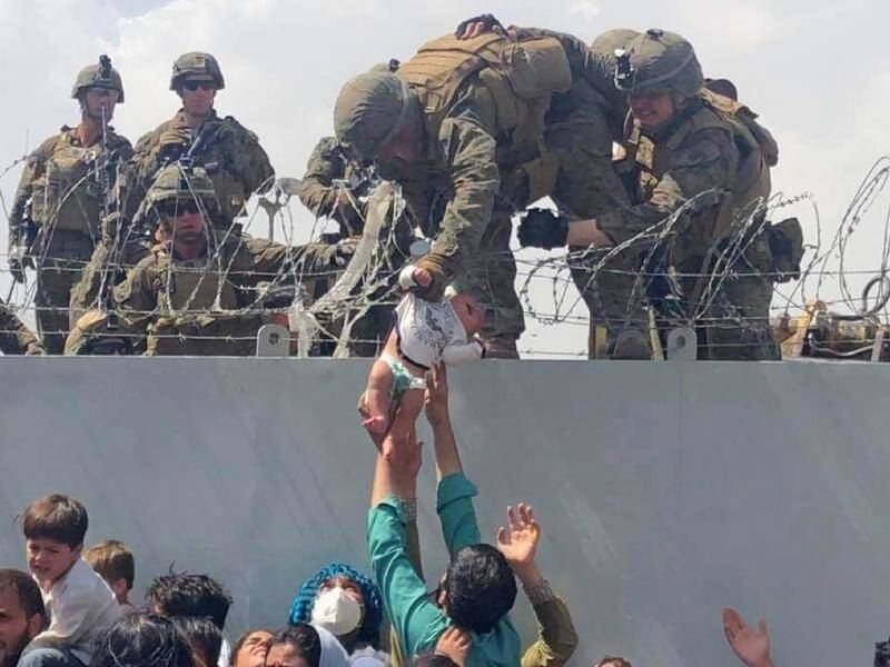 A baby handed to a soldier across a Kabul airport wall has been reunited with family months later.