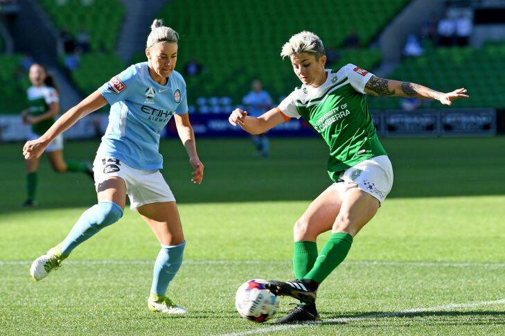 Michelle Heyman of United (right) strikes the ball past Alanna Kennedy of City during the round 7 W-League match between Melbourne City and Canberra United at AAMI Park in Melbourne, Sunday, December 10, 2017. (AAP Image/Joe Castro) NO ARCHIVING, EDITORIAL USE ONLY
