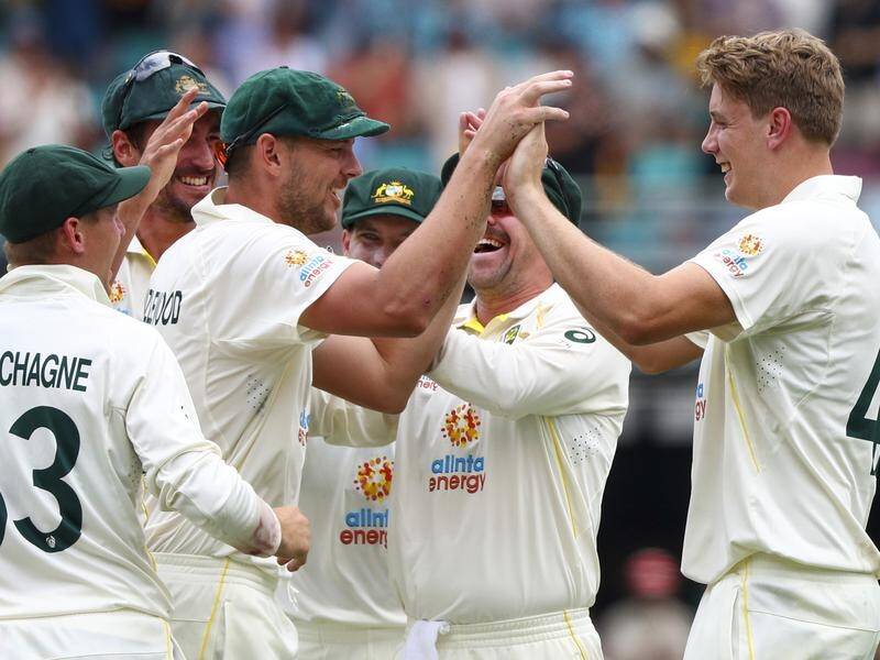 Australia's Cameron Green (r) is congratulated by teammates after his maiden Test wicket.