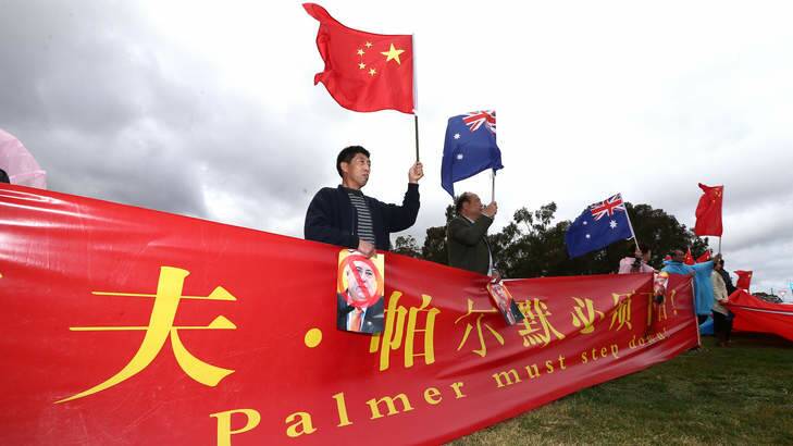 Members of the Chinese community protesting against Palmer United Party leader Clive Palmer on the front lawn of Parliament House. Photo: Alex Ellinghausen