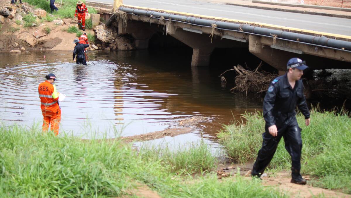 SEARCH IS ON:  Police officers, State Emergency Service crews and mine rescue workers scour the Leichhardt River near the Isa Street bridge for clues to Kyle Coleman's whereabouts yesterday.