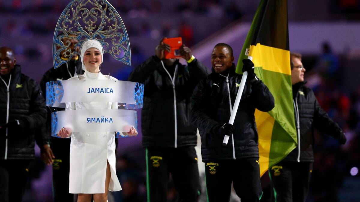 Bobsleigh racer Marvin Dixon of the Jamaica Olympic team carries his country's flag during the Opening Ceremony of the Sochi 2014 Winter Olympics. Picture: Getty