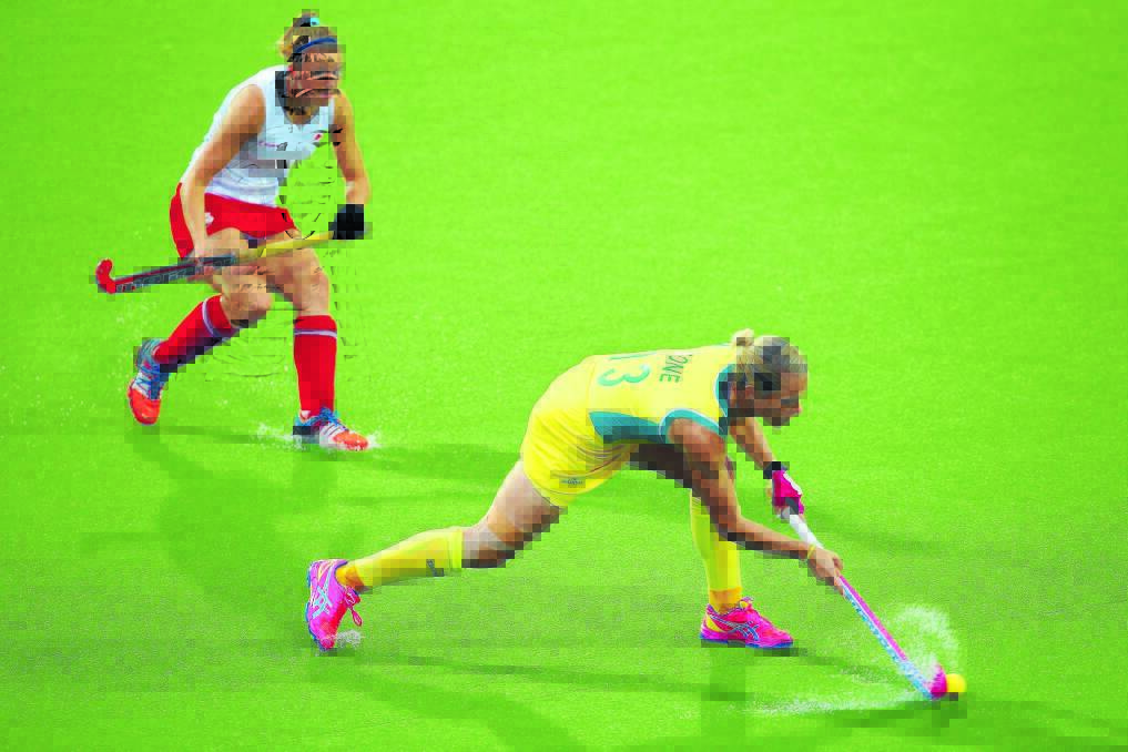 WET AND WILD: Orange’s Edwina Bone pushes the ball forward for the Hockeyroos during their Commonwealth Games gold medal match where they downed England in a penalty shootout. Photo: GETTY IMAGES