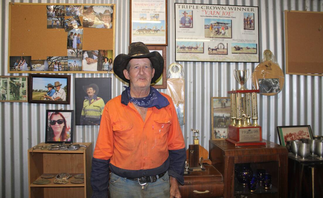 Ray Hermann in front of his trophy cabinet which is filled with rodeo buckles and horse racing trophies. Picture: Helen Walker.