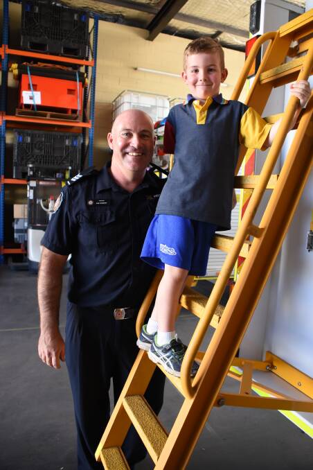 FATHER AND SON: Tully Carberry is proud of his dad Rob for finishing his firefighting training. Picture: Lydia Lynch. 
