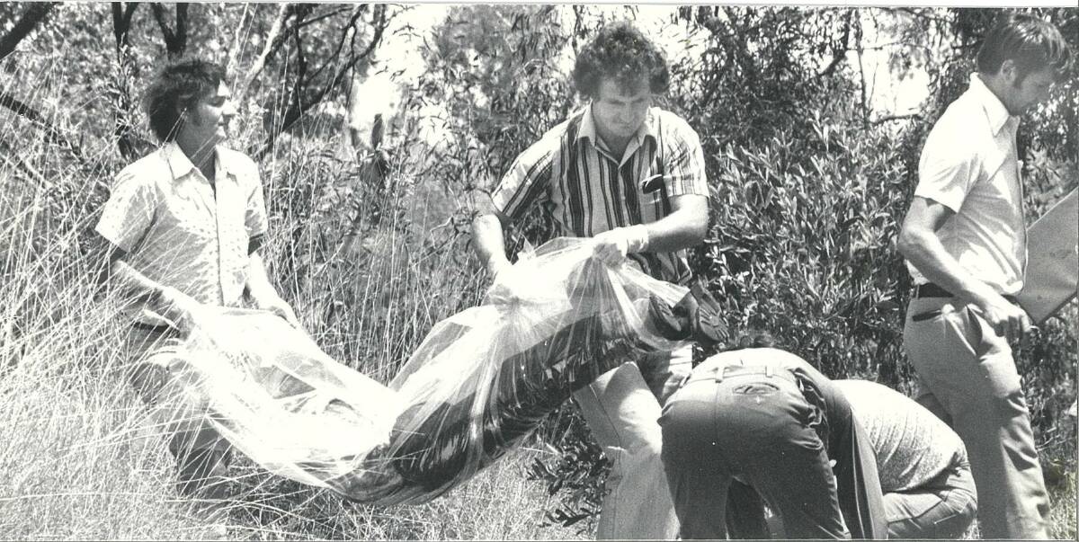 Detectives moving one of the bodies from Spear Creek in October 1978. 